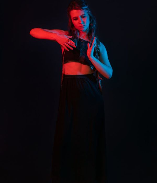 Woman in a graceful yoga pose on a dark blue background.